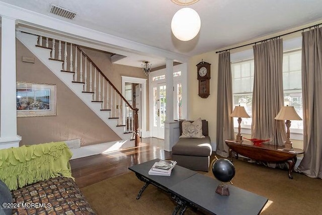 living room with hardwood / wood-style flooring, decorative columns, and a healthy amount of sunlight