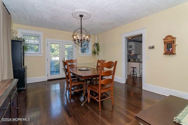 dining space with a notable chandelier, dark wood-type flooring, french doors, and a textured ceiling