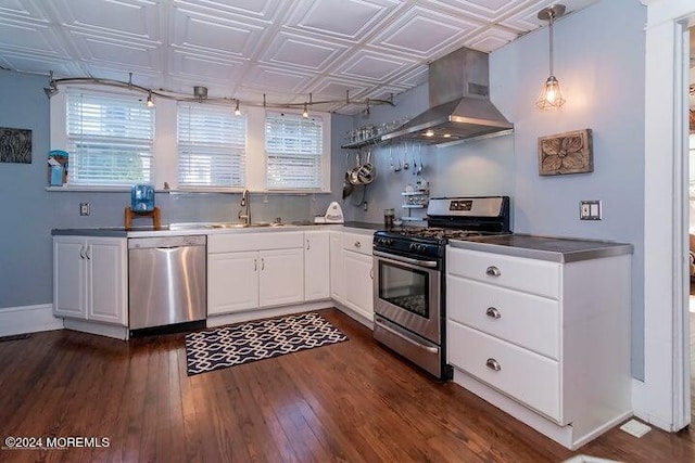 kitchen with wall chimney range hood, sink, appliances with stainless steel finishes, white cabinetry, and dark hardwood / wood-style floors