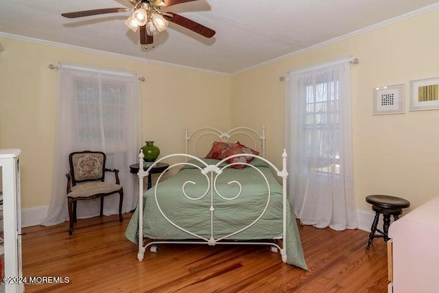 bedroom featuring wood-type flooring, ornamental molding, and ceiling fan