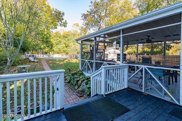 deck featuring a sunroom and ceiling fan