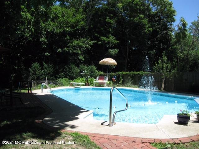 view of swimming pool featuring a diving board