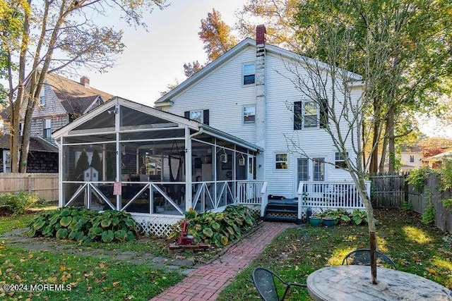 back of house with a wooden deck and a sunroom