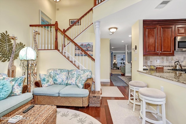 living room featuring dark hardwood / wood-style flooring and decorative columns