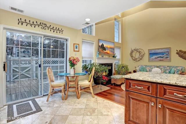 dining room with plenty of natural light, light tile patterned floors, and high vaulted ceiling