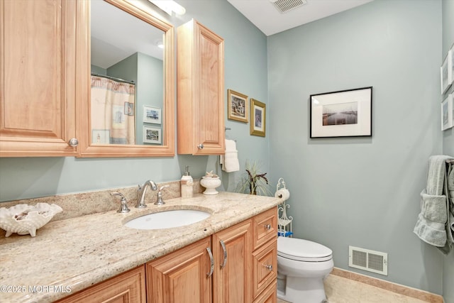 bathroom featuring vanity, tile patterned floors, and toilet