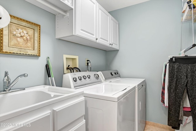 washroom featuring independent washer and dryer, cabinets, light tile patterned flooring, and sink