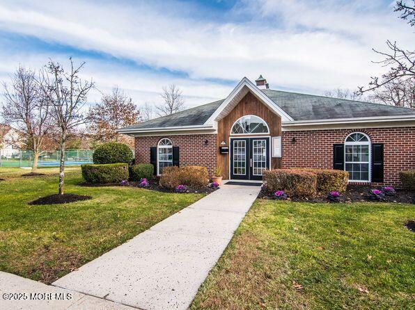 ranch-style house with a front lawn and french doors