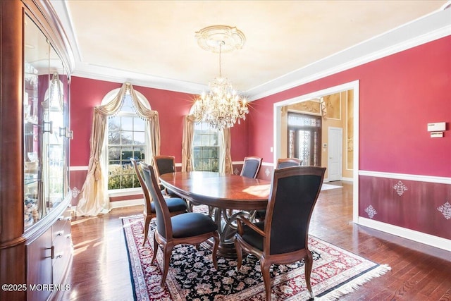 dining space with crown molding, dark hardwood / wood-style flooring, and a chandelier