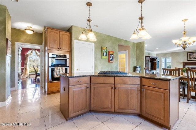 kitchen with a notable chandelier, decorative light fixtures, stainless steel appliances, and a center island