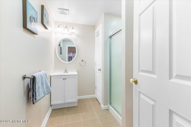 bathroom featuring tile patterned flooring, vanity, and a shower with door