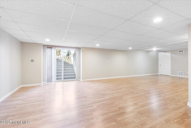 interior space with a paneled ceiling and light hardwood / wood-style flooring