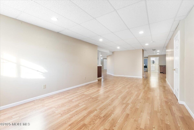 unfurnished living room featuring a paneled ceiling and light hardwood / wood-style floors