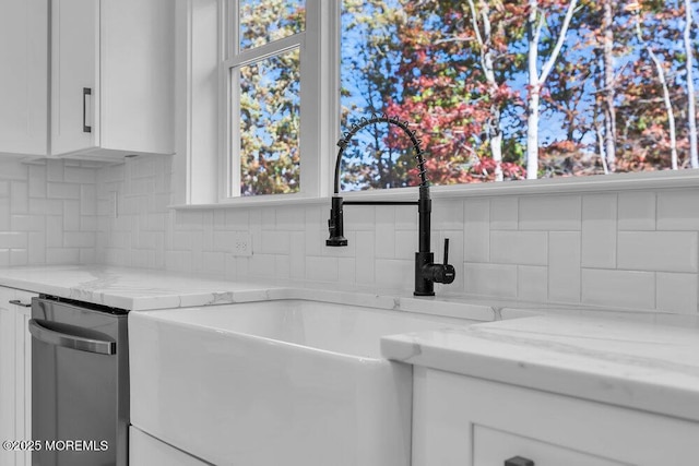 room details with sink, white cabinets, and light stone counters