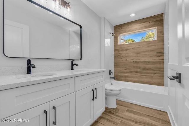 full bathroom with hardwood / wood-style flooring, shower / tub combination, vanity, and toilet