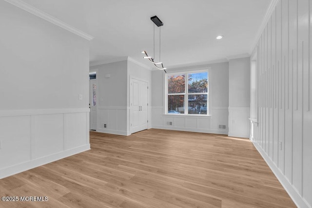 unfurnished dining area with light hardwood / wood-style flooring and ornamental molding