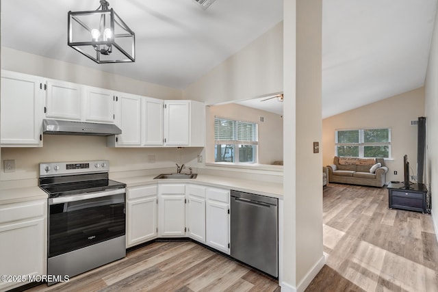 kitchen with pendant lighting, sink, appliances with stainless steel finishes, white cabinetry, and vaulted ceiling