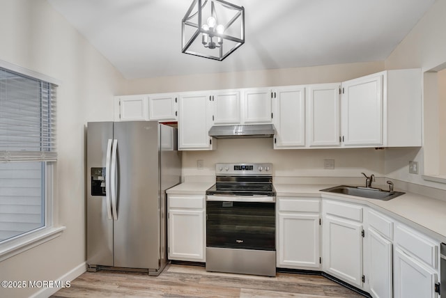 kitchen featuring appliances with stainless steel finishes, pendant lighting, sink, white cabinets, and light hardwood / wood-style flooring