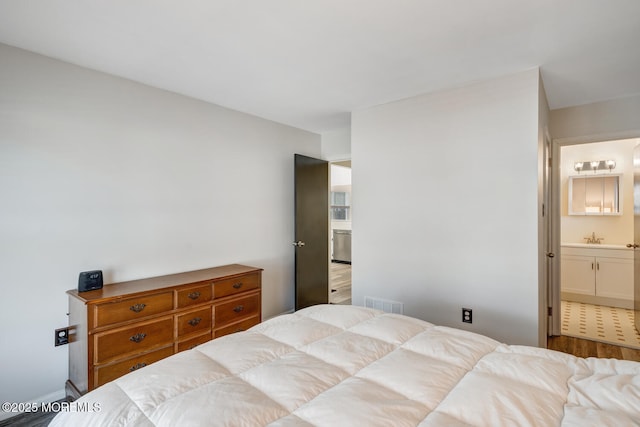 bedroom featuring wood-type flooring, sink, and ensuite bathroom