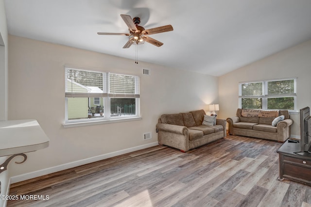 living room featuring ceiling fan, lofted ceiling, and light wood-type flooring