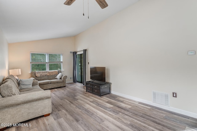 living room featuring ceiling fan, lofted ceiling, and light wood-type flooring