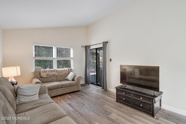 living room with vaulted ceiling and light hardwood / wood-style floors