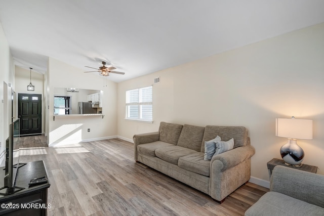 living room featuring lofted ceiling, wood-type flooring, and ceiling fan