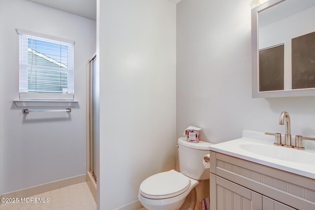 bathroom with vanity, tile patterned floors, a shower with door, and toilet