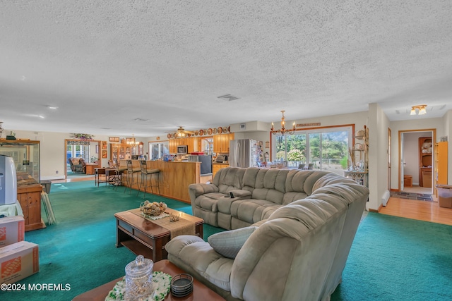 carpeted living room with a chandelier and a textured ceiling