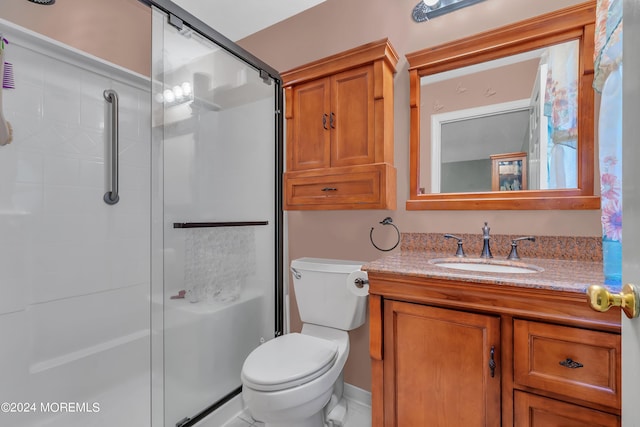 bathroom with walk in shower, vanity, and toilet