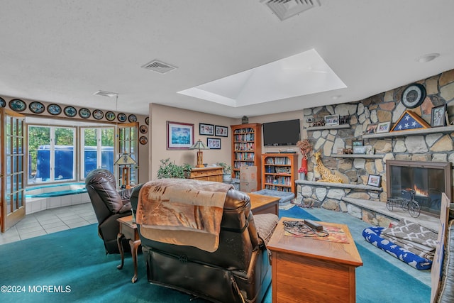 tiled living room featuring a fireplace and a skylight