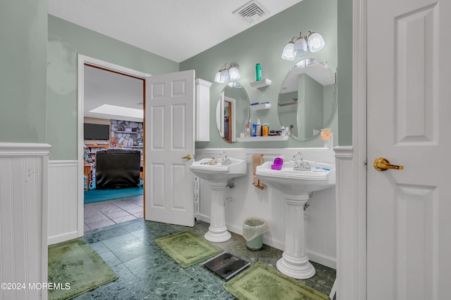 bathroom featuring tile patterned floors and a textured ceiling