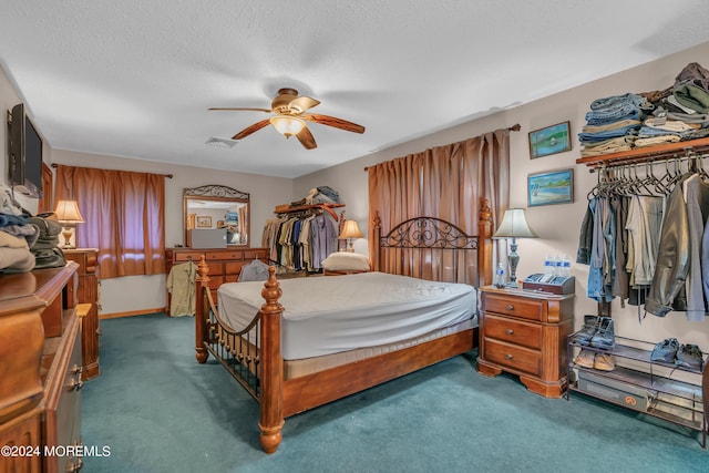 bedroom with ceiling fan, a textured ceiling, and dark colored carpet