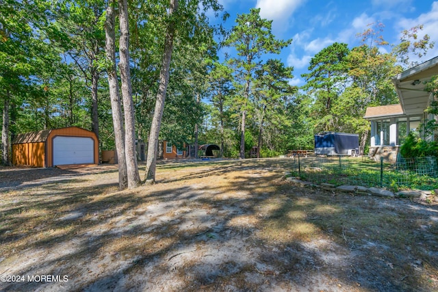 view of yard featuring a garage and an outbuilding