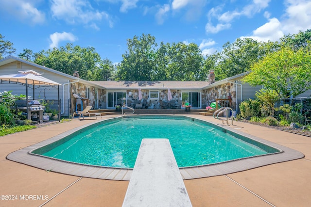 view of pool with a gazebo, a diving board, and a patio