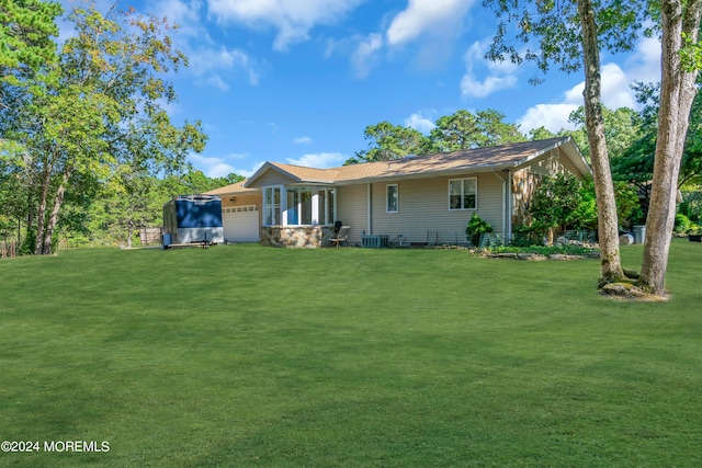 view of front of property with a garage, central AC, and a front yard