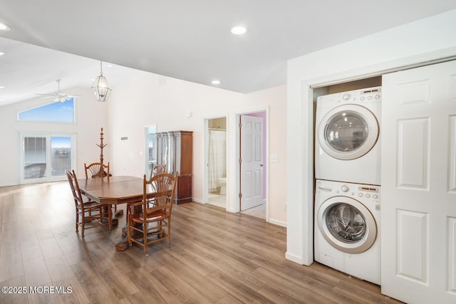 interior space with ceiling fan, lofted ceiling, stacked washer / dryer, and wood-type flooring