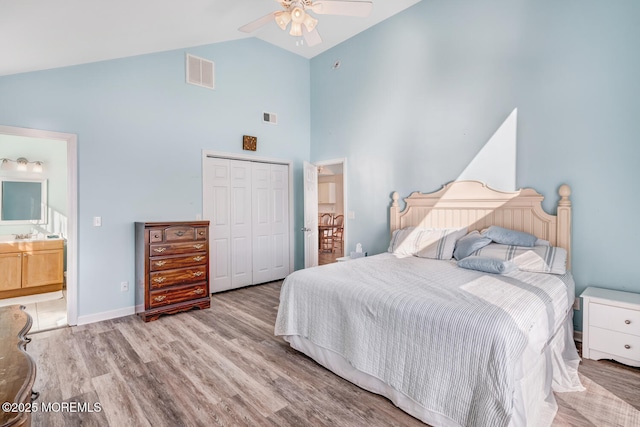 bedroom with ensuite bathroom, high vaulted ceiling, light hardwood / wood-style flooring, a closet, and ceiling fan