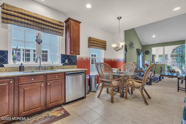 kitchen featuring lofted ceiling, sink, a chandelier, hanging light fixtures, and stainless steel dishwasher