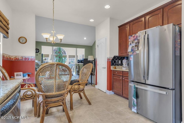 dining room featuring an inviting chandelier, lofted ceiling, and light tile patterned flooring