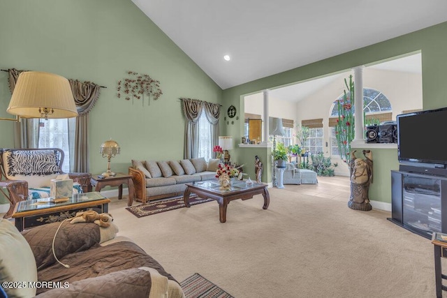 living room featuring plenty of natural light, light carpet, and high vaulted ceiling