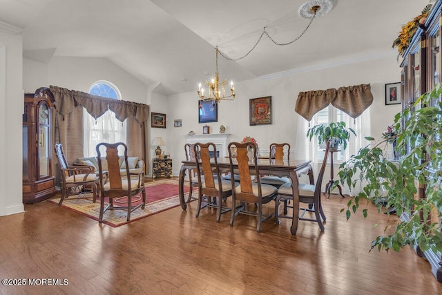 dining area featuring hardwood / wood-style flooring, vaulted ceiling, and a notable chandelier