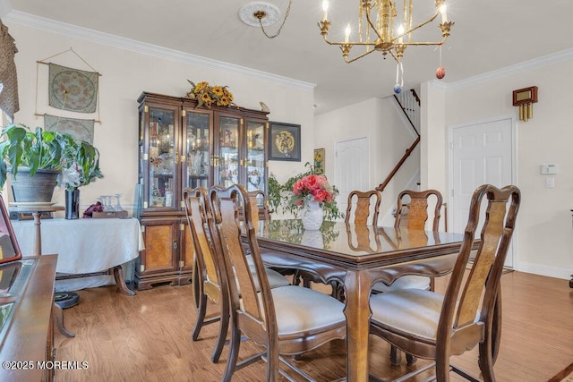 dining space with a notable chandelier, wood-type flooring, and ornamental molding