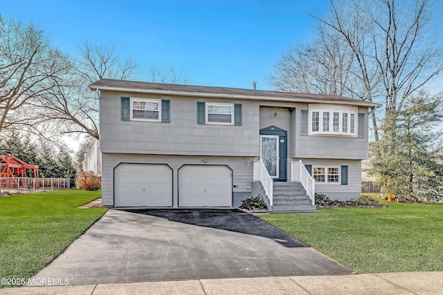 raised ranch featuring a garage and a front lawn