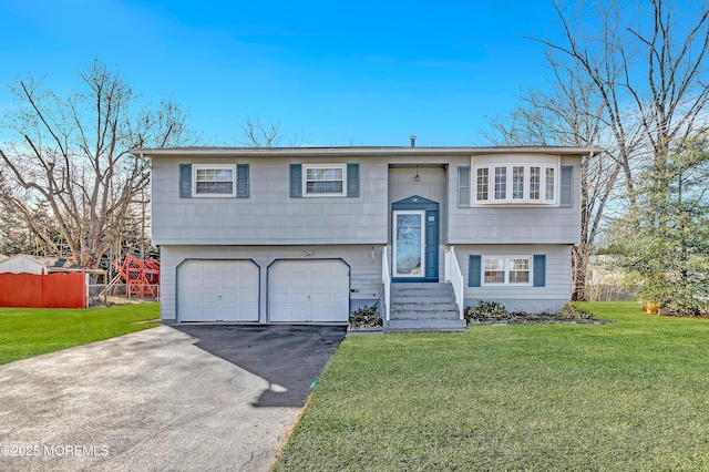 bi-level home featuring a garage and a front lawn