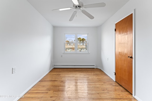 spare room with a baseboard heating unit, ceiling fan, and light wood-type flooring