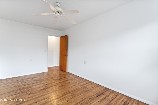 empty room with hardwood / wood-style flooring and ceiling fan