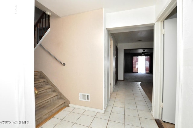 staircase featuring tile patterned floors and ceiling fan