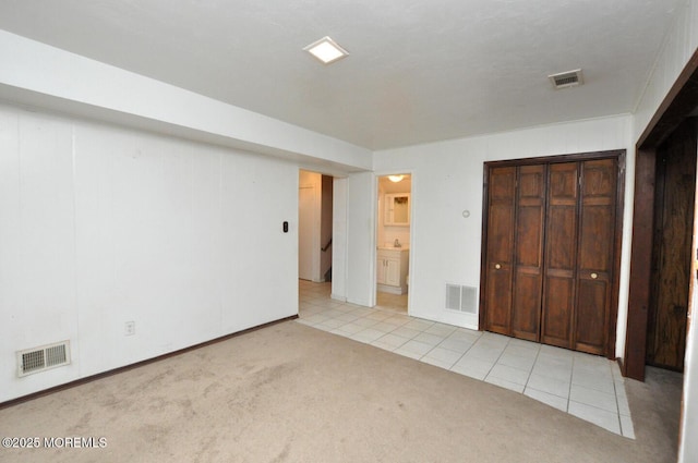 unfurnished bedroom featuring connected bathroom and light colored carpet