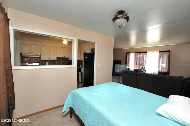 carpeted bedroom with black fridge